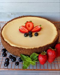 Keto Cheesecake garnished with strawberries and blueberries and a mint leaf